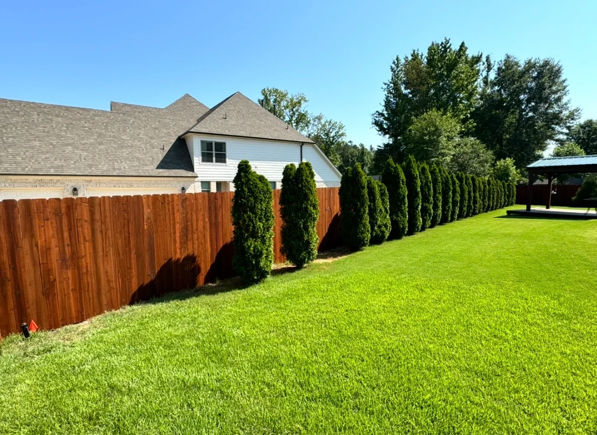 Second view of the pre-stained cedar privacy fence running past a covered backyard pavilion
